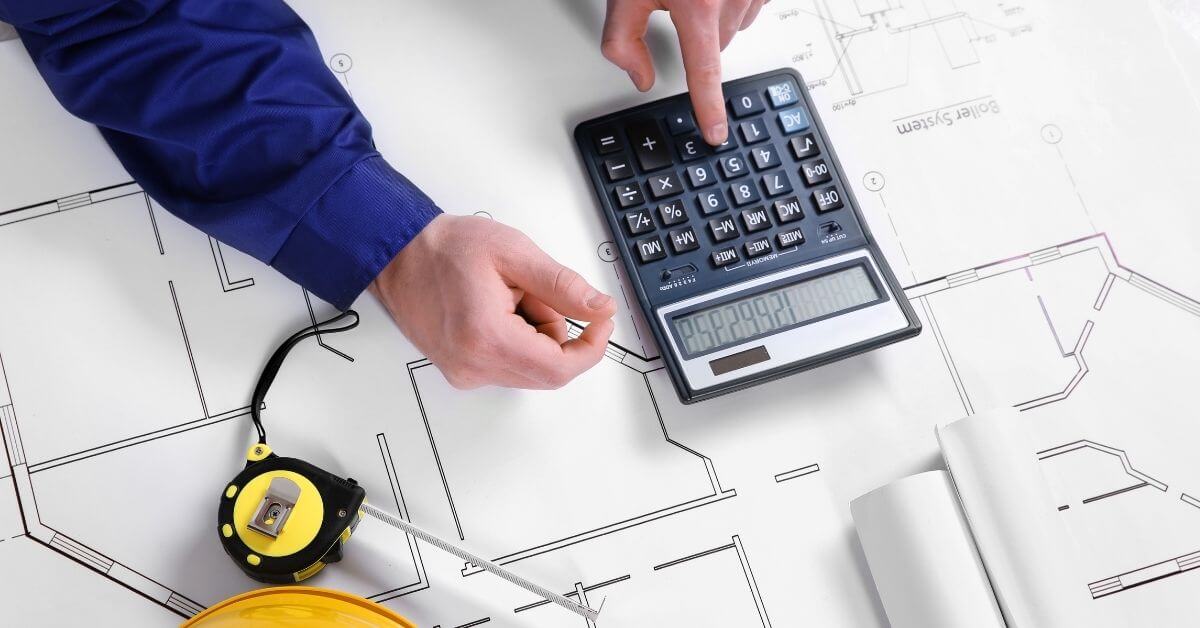 Why it is important to give your contractor a budget - yellow hard hat, blueprints, and calculator