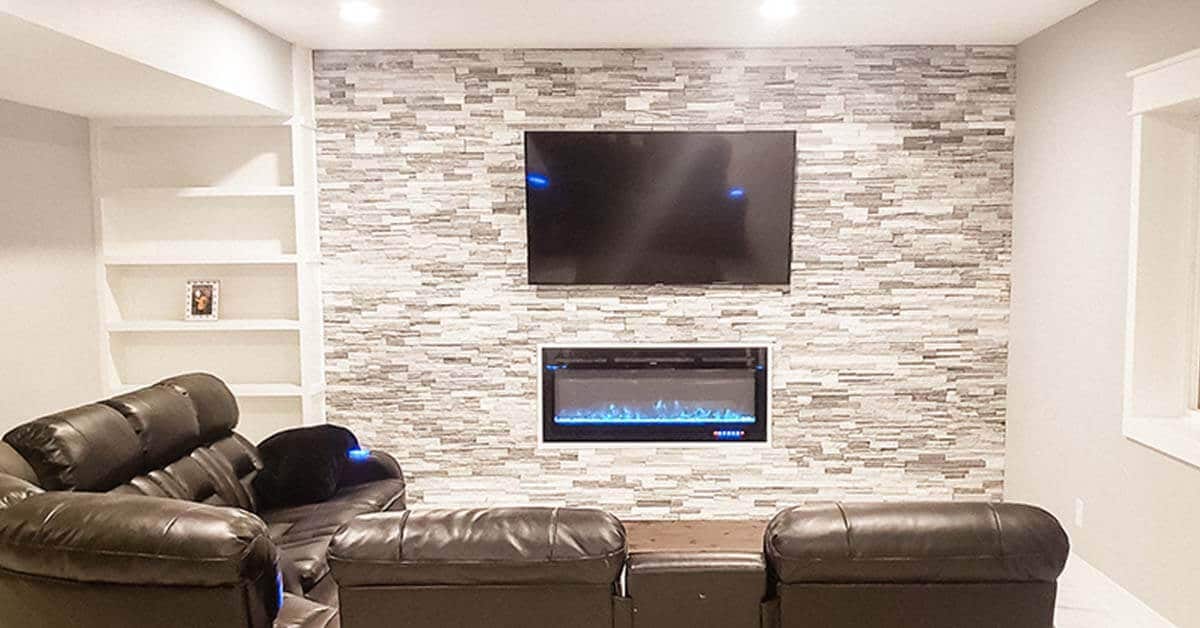 5 reasons to finish your basement - brown leather couch with modern fireplace and tv above with stone wall