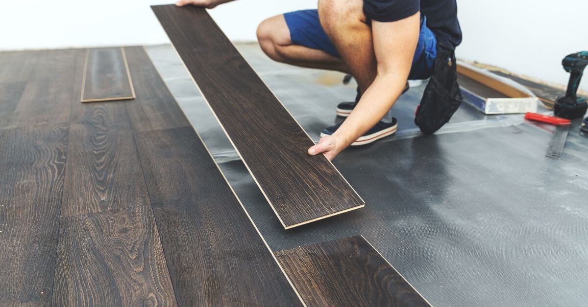 Basement Flooring Ideas - Man installing Luxury Vinyl Plan Flooring