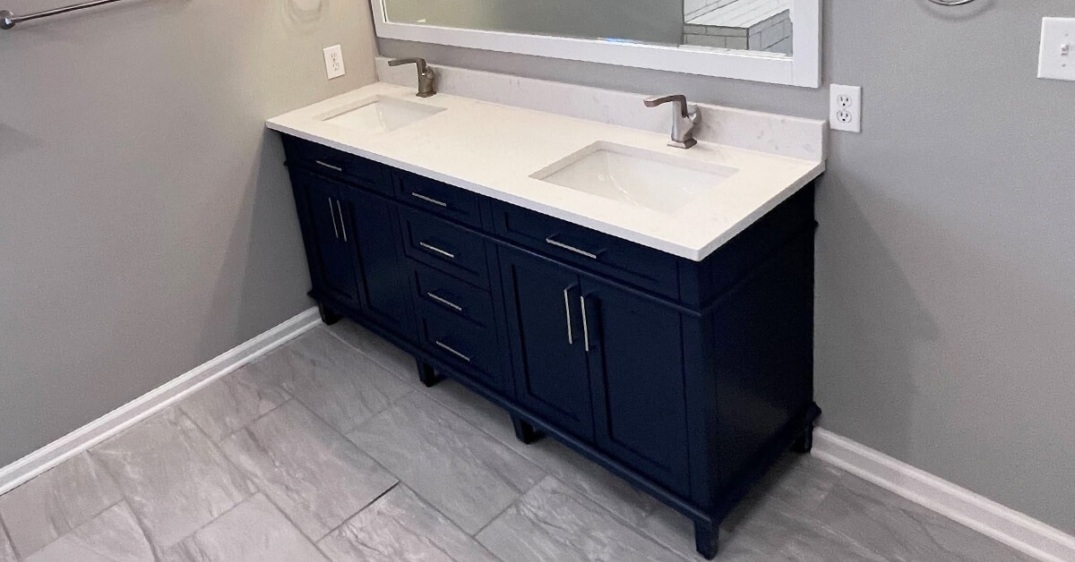Brownsburg, Indiana Master Bathroom remodel - navy blue cabinets with white marble countertop.